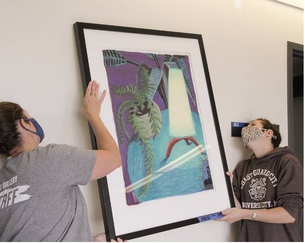 staff members installing art